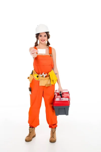 Beautiful workwoman in uniform holding toolbox and business card, isolated on white — Stock Photo