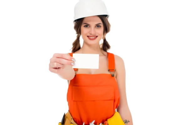 Smiling workwoman in uniform and hardhat holding business card, isolated on white — Stock Photo