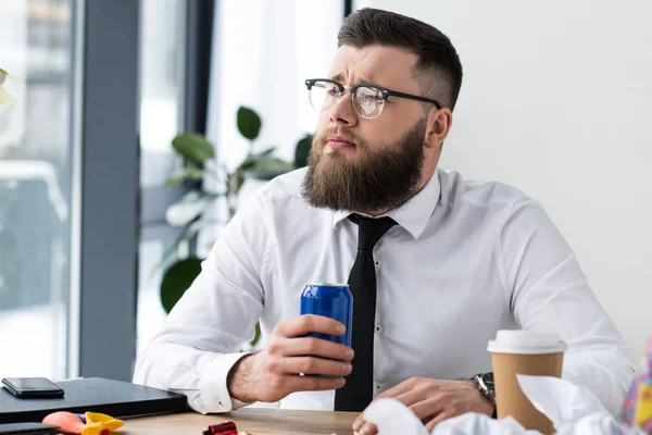 Portrait of pensive businessman in formal wear with soda drink at workplace in office — Stock Photo