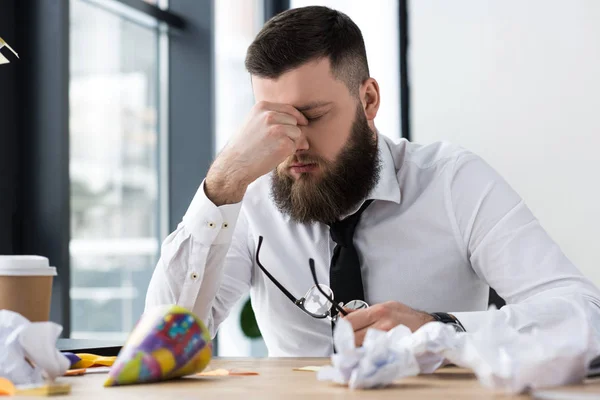 Porträt eines überlasteten Geschäftsmannes am Arbeitsplatz im Büro — Stockfoto