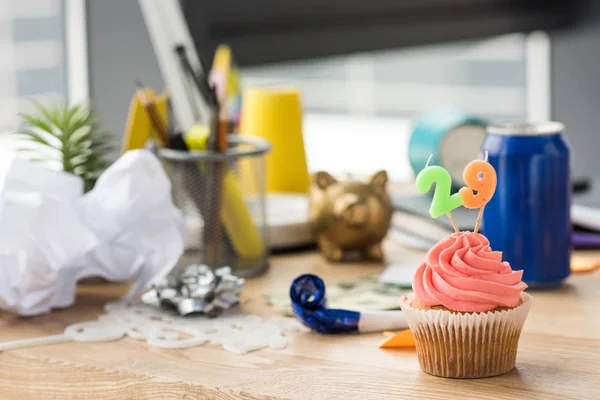 Foco selectivo de cupcake de cumpleaños y decoraciones de fiestas en el lugar de trabajo - foto de stock