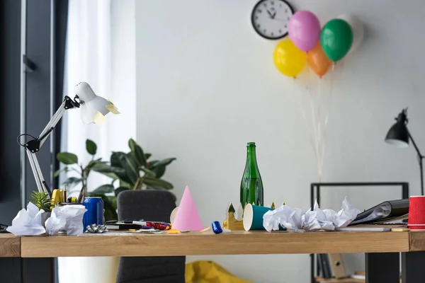 Party decorations, bottle of champagne and balloons in office — Stock Photo