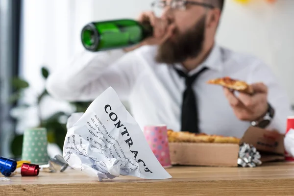 Selective focus of businessman drinking champagne and eating pizza at workplace — Stock Photo