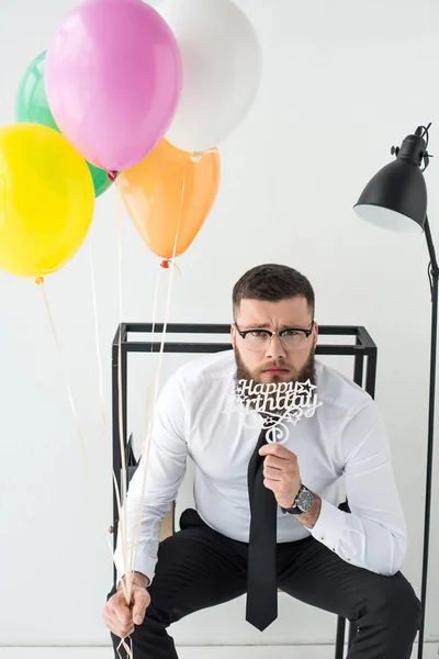 Portrait d'homme d'affaires en tenue formelle avec signe joyeux anniversaire et ballons — Photo de stock