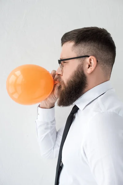 Side view of bearded businessman in formal wear with balloon isolated on grey — Stock Photo