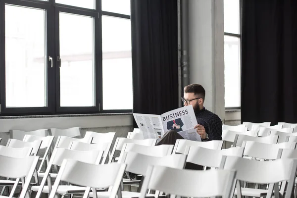 Homme d'affaires lisant le journal assis dans la salle de réunion — Photo de stock