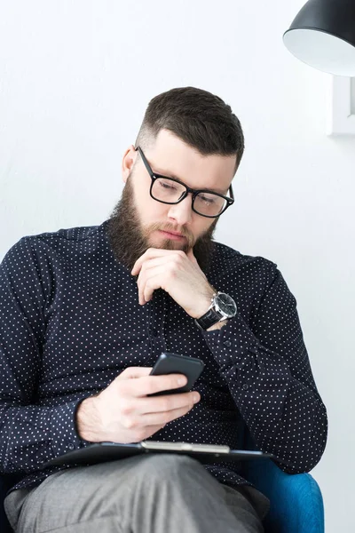 Retrato de homem de negócios com notepad usando smartphone — Fotografia de Stock