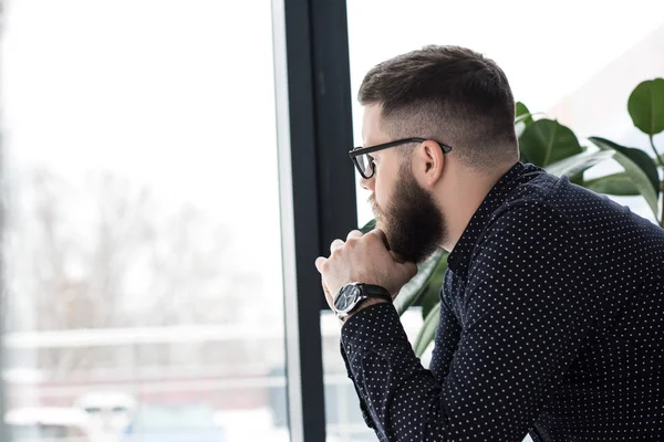 Seitenansicht eines nachdenklichen Mannes mit Brille, der wegschaut — Stockfoto