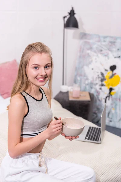Mujer joven en forma comiendo desayuno de cereales - foto de stock