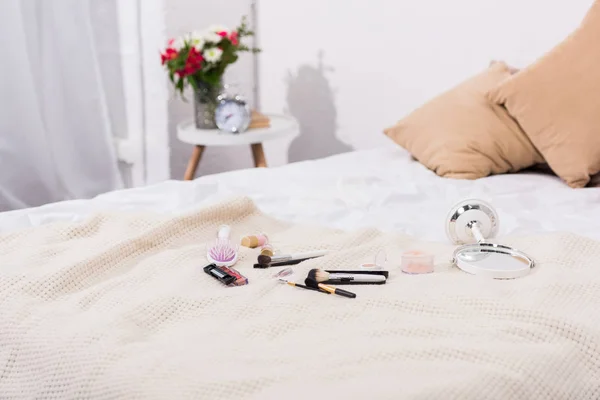 Gros plan sur les fournitures de maquillage couchées sur le lit — Photo de stock