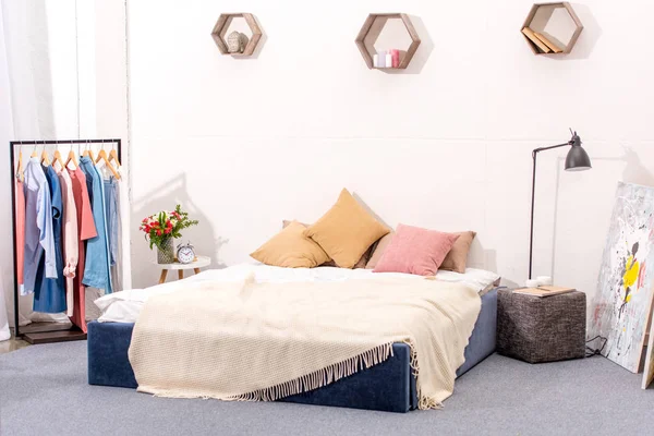 Intérieur de la chambre à coucher avec décor élégant et cintre plein de divers vêtements féminins — Photo de stock