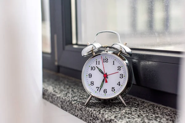 Nahaufnahme eines alten Weckers auf der Fensterbank — Stockfoto