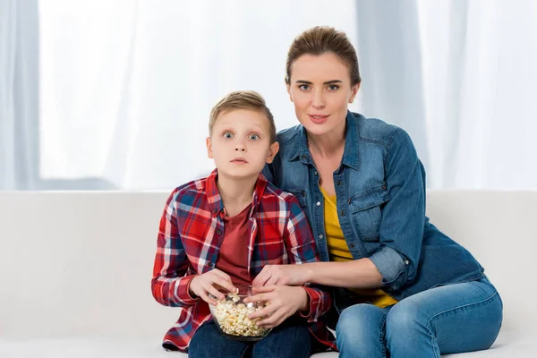 Interested mother and son watching movie together with popcorn — Stock Photo