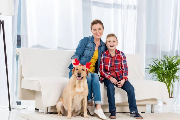 Mutter und Sohn verbringen Zeit mit ihrem Hund zu Hause und schauen in die Kamera — Stockfoto