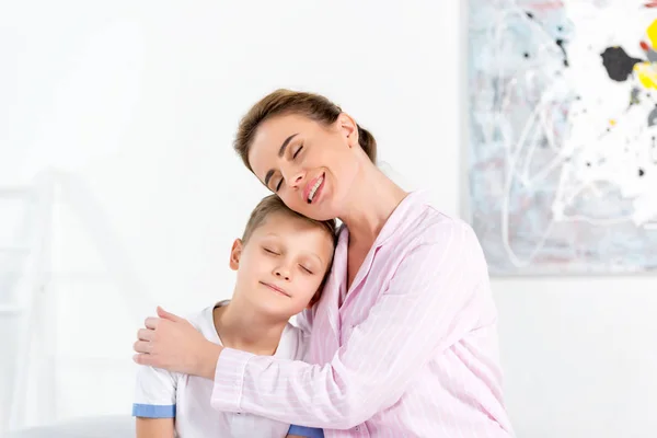 Mother and son embracing in pajamas in morning — Stock Photo