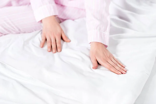 Plan recadré de femme touchant drap de lit blanc propre — Photo de stock