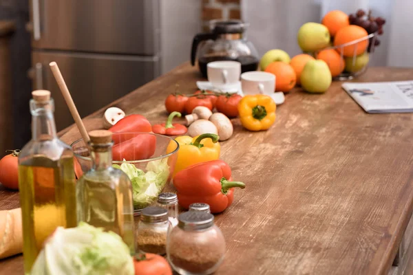 Tazas con café y verduras con frutas en mesa de madera - foto de stock