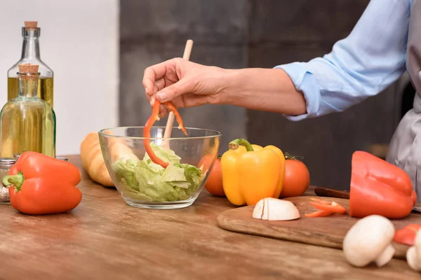Cropped image of woman mixing salad in glass bowl — Stock Photo