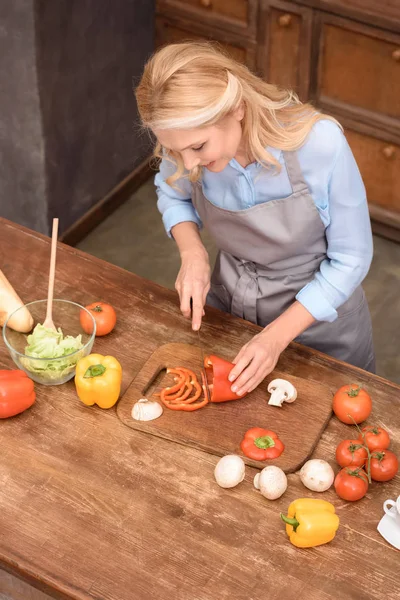 Vista de ángulo alto de la mujer cortar verduras - foto de stock