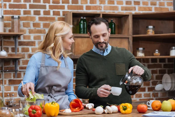 Husband pouring coffee in cup for wife — Stock Photo