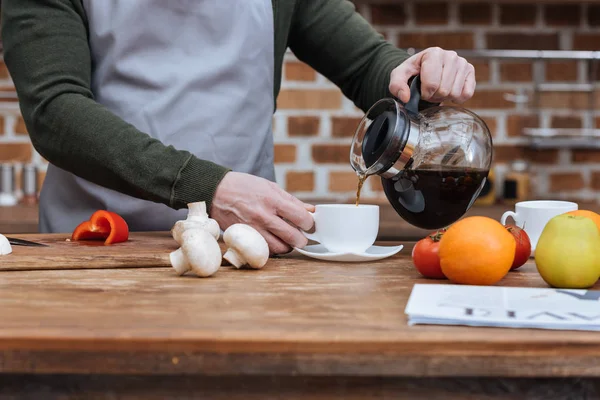 Imagen recortada del hombre vertiendo café en la taza - foto de stock