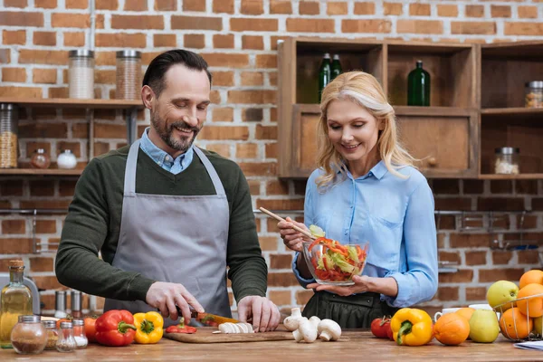 Happy affectionate couple preparing salad — Stock Photo