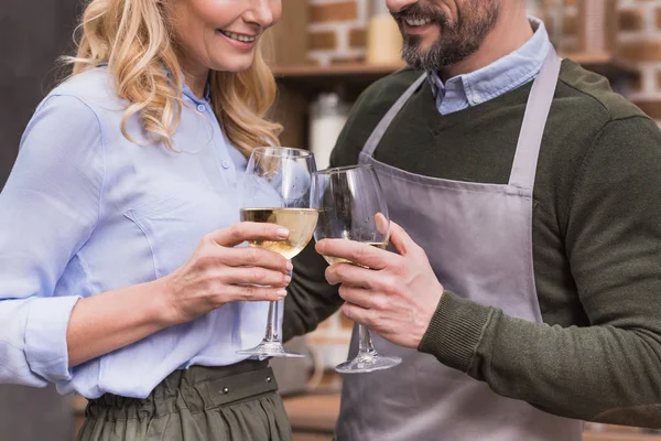 Cropped image of husband and wife toasting with glasses of wine — Stock Photo