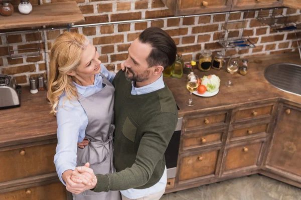 Overhead view of smiling wife and husband dancing on kitchen — Stock Photo