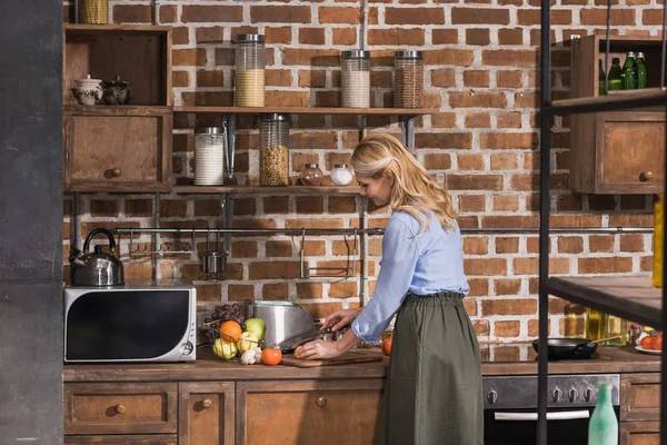 Seitenansicht einer Frau bei der Zubereitung in der Küche — Stockfoto