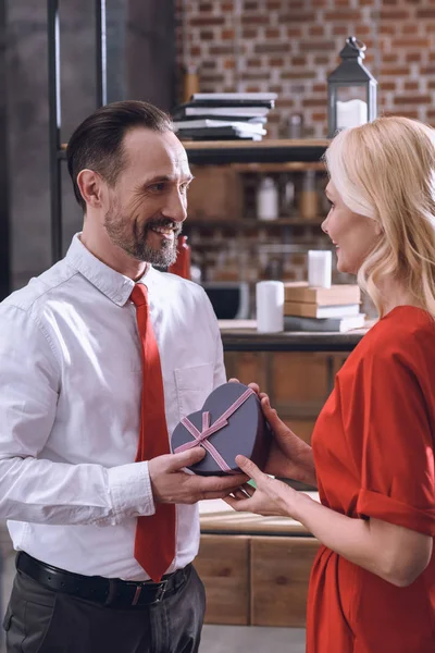 Seitenansicht von Mann schenkt Geschenk an Frau, Valentinstag-Konzept — Stockfoto