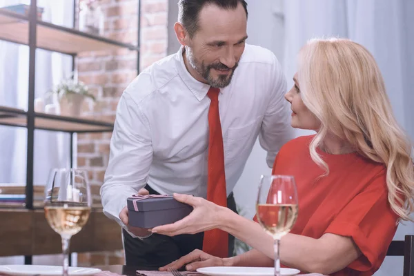 Mann überreicht Geschenk an Frau, Valentinstag-Konzept — Stockfoto