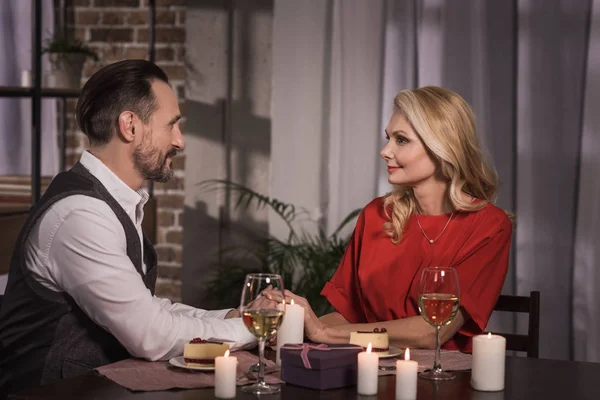 Side view of couple holding hands and looking at each other at romantic date — Stock Photo