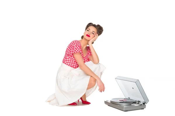 Nachdenkliche Frau in Pin-up-Klamotten hört Phonograph isoliert auf Weiß — Stockfoto