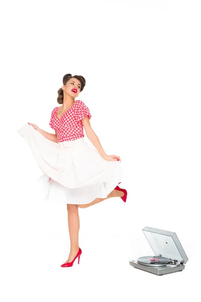 Woman in pin up style clothing dancing near phonograph isolated on white — Stock Photo