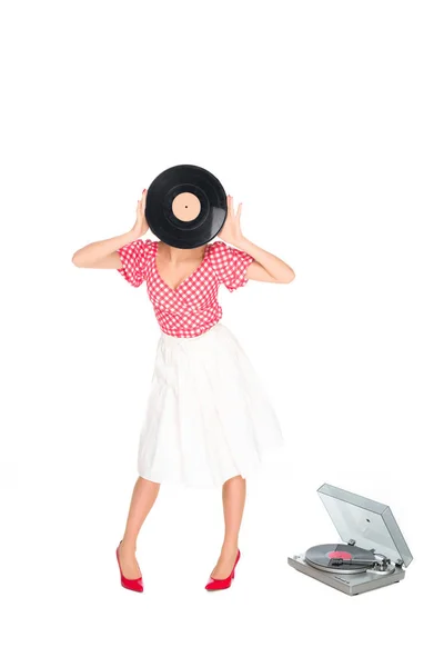 Vista oscurecida de la mujer en pin up estilo de la ropa que cubre la cara con disco de vinilo aislado en blanco - foto de stock