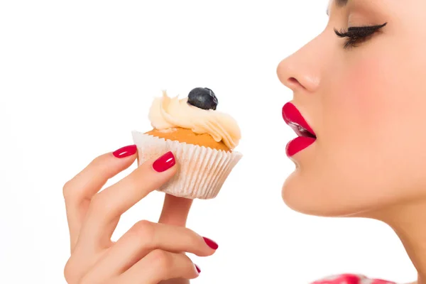 Vista laterale di bella donna con cupcake in mano isolato su bianco — Foto stock