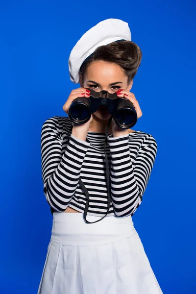 Jovem atraente em roupas retro com binóculos isolados em azul — Fotografia de Stock