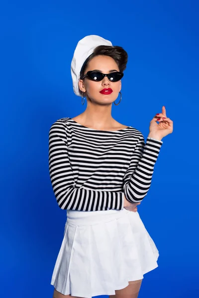 Portrait of stylish woman in retro clothing and sunglasses isolated on blue — Stock Photo