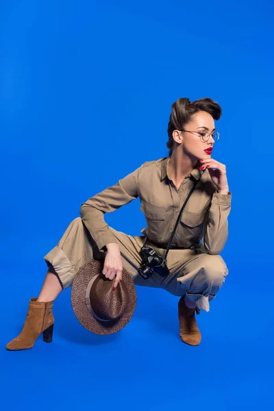 Stylische junge Frau in Retro-Kleidung mit Hut in der Hand isoliert auf blau — Stockfoto