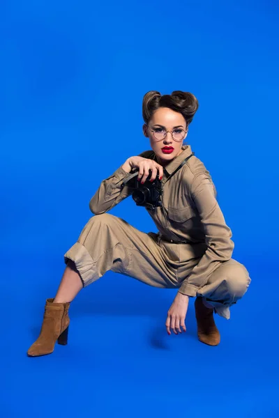 Fashionable young woman in retro clothing with photo camera isolated on blue — Stock Photo