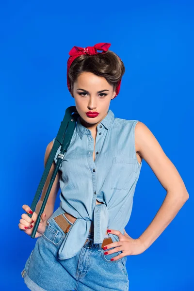 Jeune femme à la mode en pin up style vêtements avec clé isolée sur bleu — Photo de stock