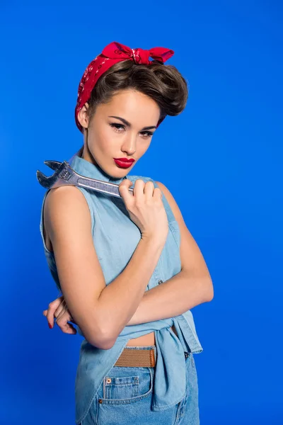 Mulher jovem na moda em pin up estilo roupas com chave isolada em azul — Fotografia de Stock