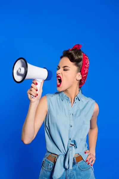 Mujer joven de moda en ropa de estilo pin up con altavoz aislado en azul - foto de stock