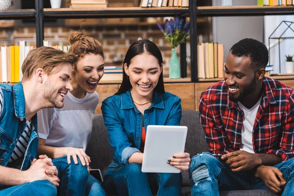 Heureux jeunes amis multiethniques utilisant tablette numérique ensemble — Photo de stock