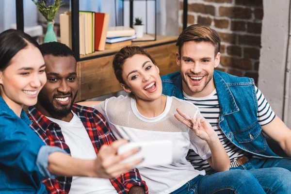 Happy young multiethnic friends taking selfie with smartphone — Stock Photo