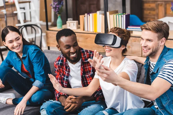 Happy young multiethnic friends having fun with virtual reality headset at home — Stock Photo