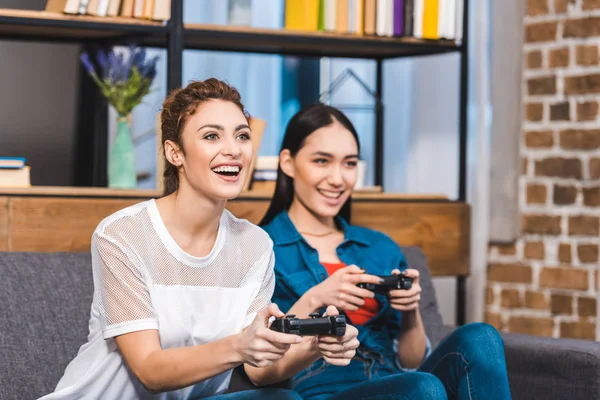 Belas mulheres multiétnicas jovens brincando com joysticks juntos — Fotografia de Stock