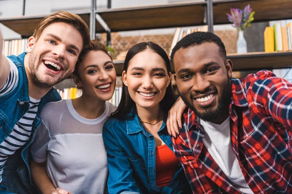 Heureux jeunes amis multiethniques souriant à la caméra — Photo de stock