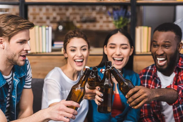 Felici giovani amici multietnici clinking bottiglie di birra — Foto stock