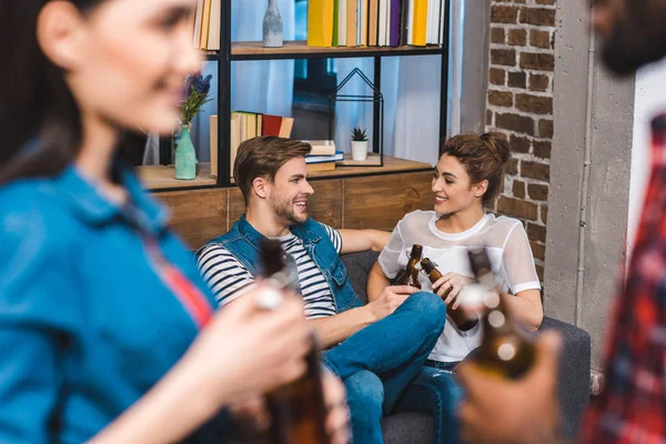 Enfoque selectivo de jóvenes amigos sonrientes bebiendo cerveza juntos - foto de stock